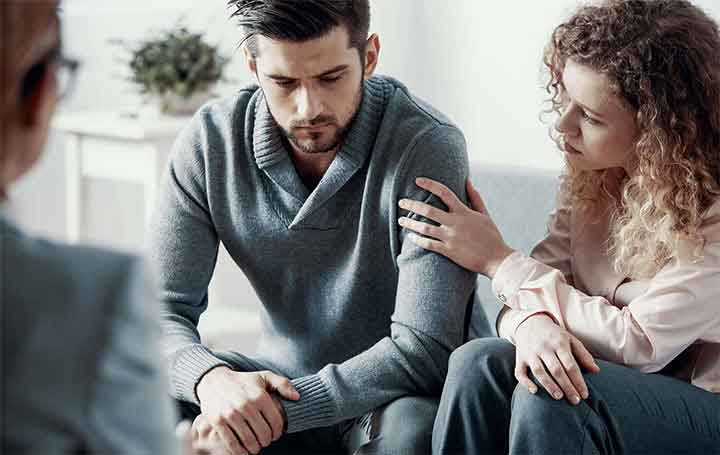 Imagen de una pareja adulta sentada en un sillón y recibiendo terapia